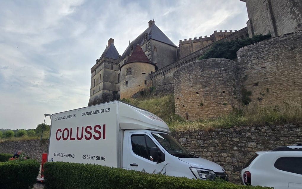 Camion de déménagement Colussi garé au pied d'un château